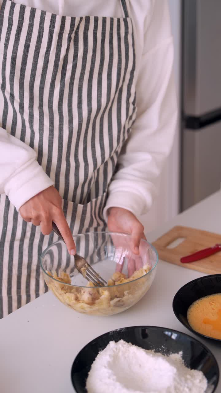 Woman's Hands Mashing Bananas in a Glass Bowl