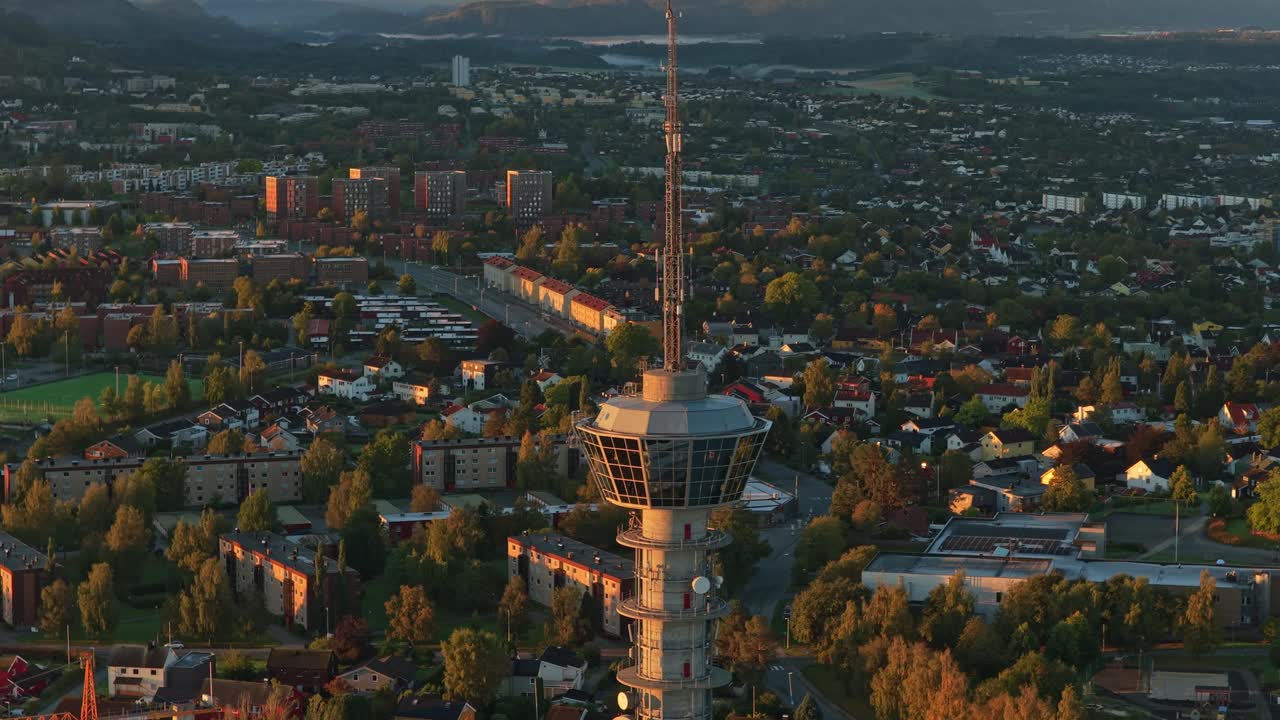 Altın gün doğumu vaktinde Tyholt Kulesi ile Trondheim'ın panoramik havadan görünümü.