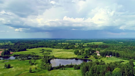 Bird's-eye-view-of-a-mixed-landscape,-green-meadows,-forests-and-small-lakes