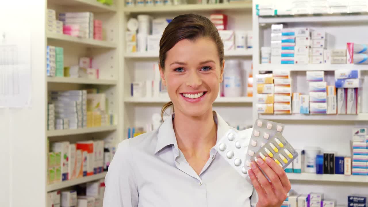 약국 에서 약 을 보여 주는 미소 짓는 약사