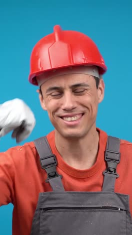 smiling construction worker in hard hat and overalls