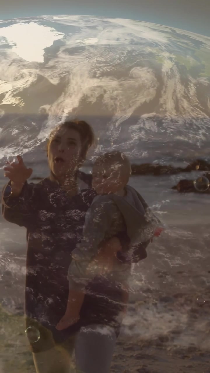 Video vertical: Hombre sosteniendo a un niño pequeño soplando una burbuja, iniciando una superposición de globo que muestra una playa para viajar.