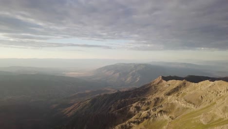 mt nebo salt lake city utah at sunrise sunset on a cloudy day with morning light spilling on the mountain - aerial tilt