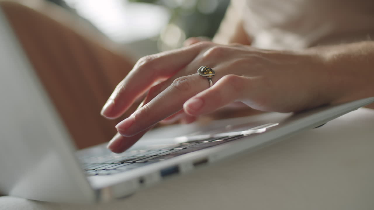 manos femeninas escribiendo en una computadora portátil
