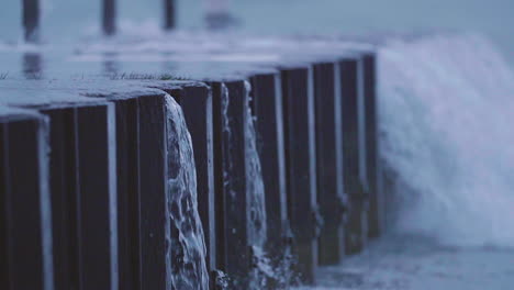 lakeside water pours down from the lip of a pier