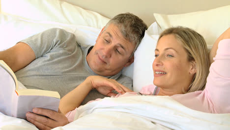 Pareja-Leyendo-Un-Libro-En-La-Cama