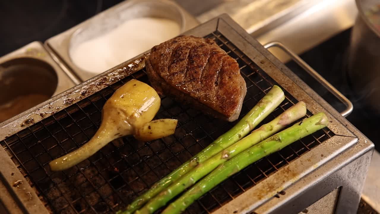 小さなグリルで肉、アーティチョーク、アスパラガスを焼く