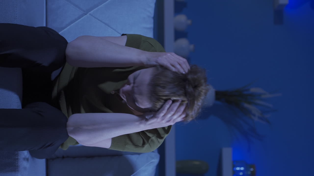 집에서 신경 ⁇ 약을  ⁇ 고 있는 여성의 수직 비디오가 소리를 지르고 있습니다.