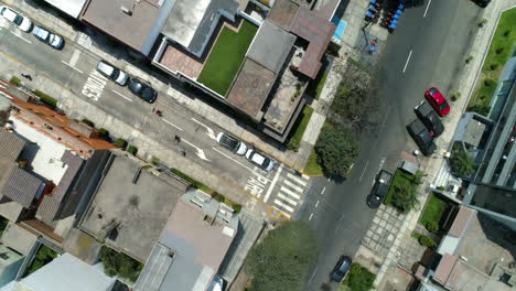 aerial birds eye shot tracking people skating across the streets of sunny lima
