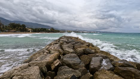 Toma-4k-De-Rocas-Junto-Al-Puerto-Y-La-Playa-En-Marbella,-España