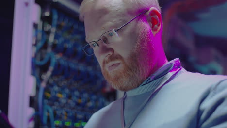it engineer working in a data center with neon lights
