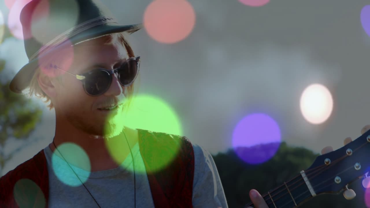 Kamera trekker seg tilbake og avslører solo-gitarist som klimprer på nylonstrenger med bokeh-kuler for live musikk