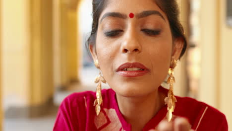 close-up of smiling indian woman blowing glitter