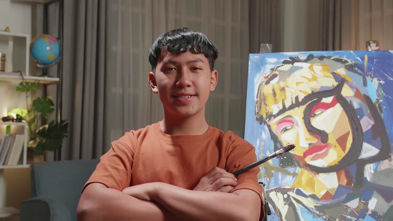 Asian Artist Boy In Wheelchair Holding Paintbrush And Cross His Arms And Smile While Painting A Girl On The Canvas