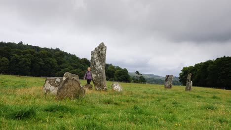 Lady-walks-past-standing-stones-in-Kilmartin-Glen