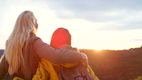 two women embrace at sunset