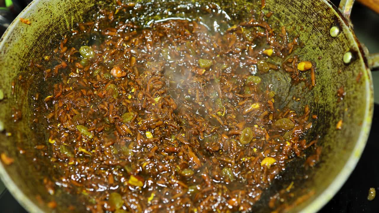 Indian sweet ginger halwa cooking in pan with nuts and ghee