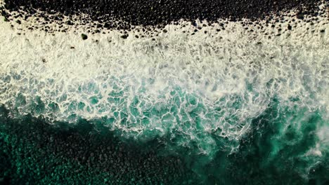 aerial view of volcanic coastline with waves