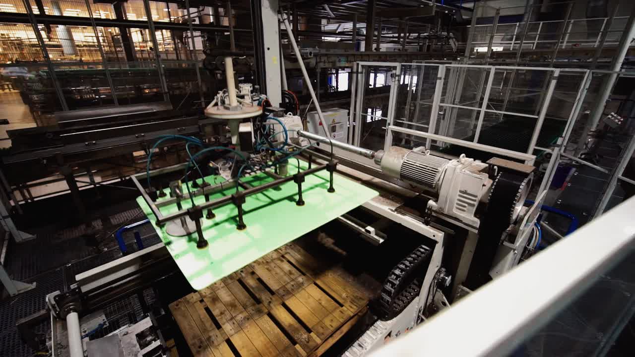 Automated Manufacturing plant removing green material from wooden pallets on swinging arm
