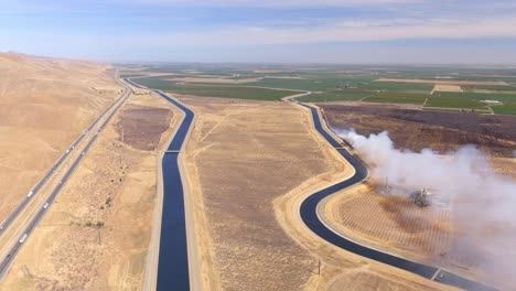 a burning wildfire in california's central valley during the dry season - pull back aerial view