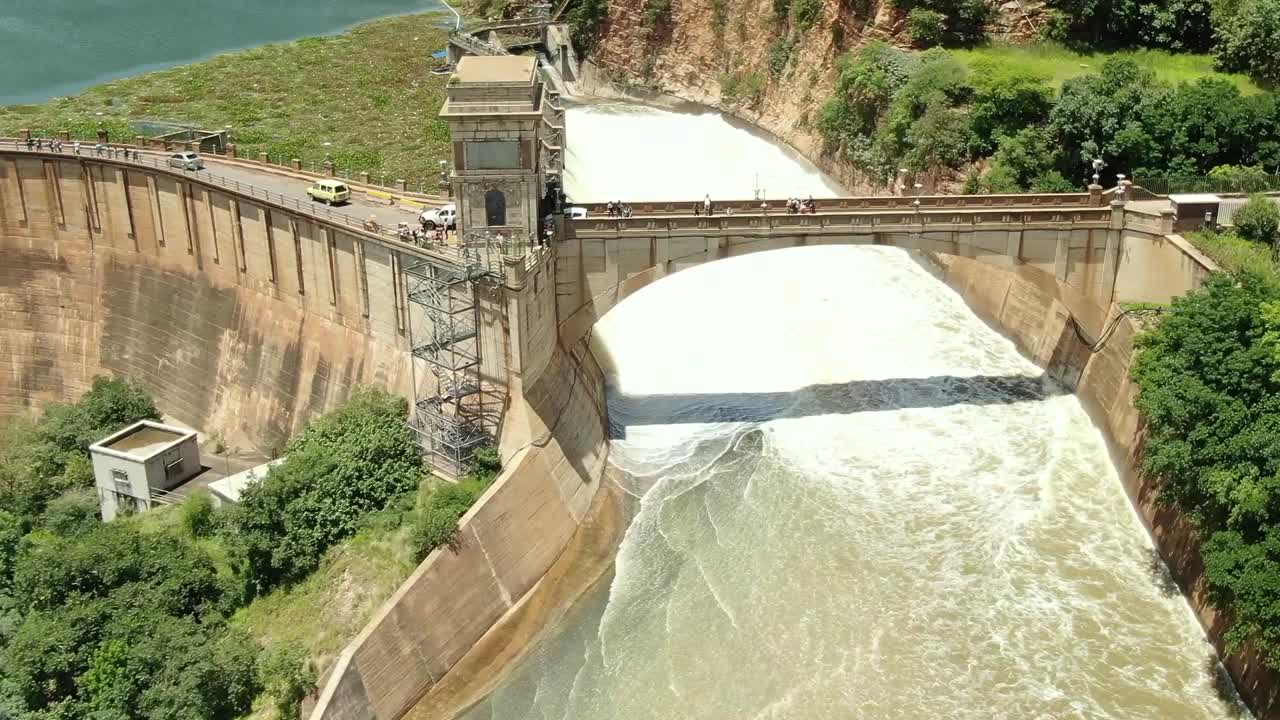 Dam overflowing into river all sluice gates open
