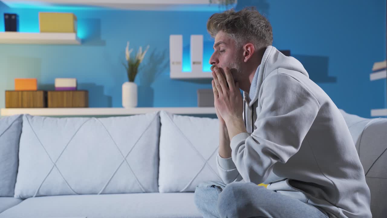un joven nervioso y estresado solo en casa pensativo e infeliz.