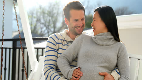pregnant couple sitting in swing 4k