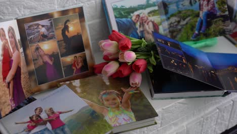 photo book and flowers tulips as a holiday gift lie on the shelf