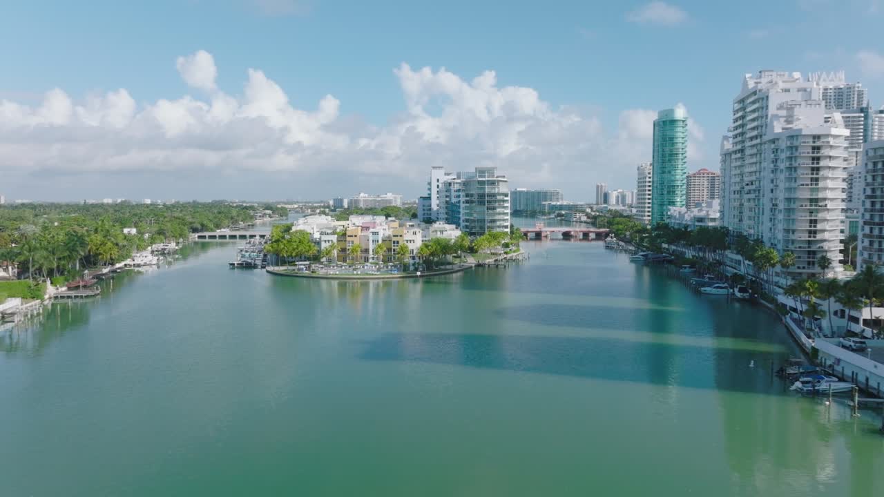 바 ⁇ 가에 있는 높은 아파트 건물의 뒤집힌 모습. 마을의 평온한 물 표면 위에서 날아갑니다. 마이애미, 미국