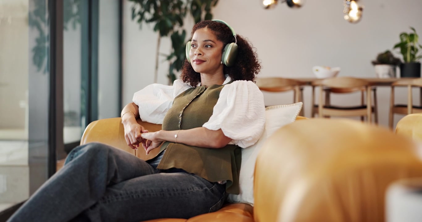 Young Woman Relaxing on Sofa Wearing Headphones