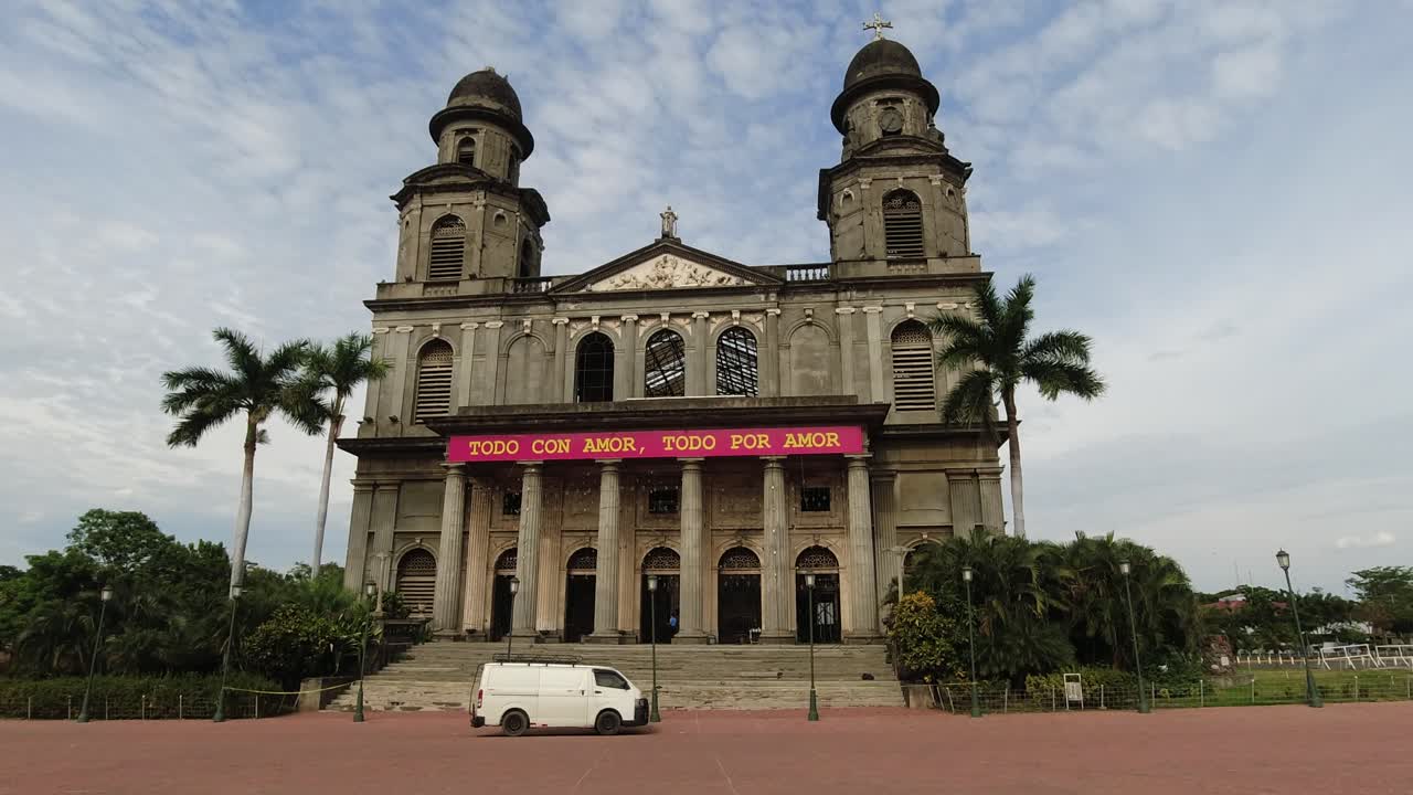una pequeña furgoneta conduce hasta la fachada delantera de la antigua catedral en managua, nic.