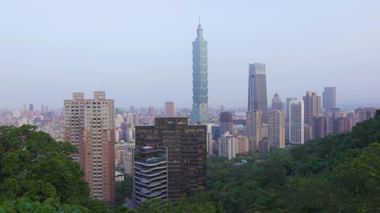 amanecer sobre la torre taipei 101 en la ciudad de taipei, taiwán con árboles en primer plano