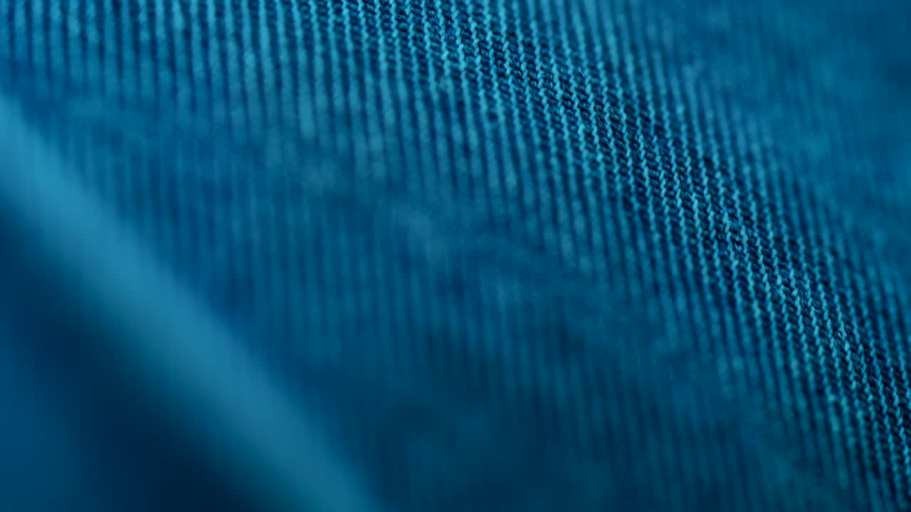 Close up of blue fabric texture showing fine threads and detailed textile pattern