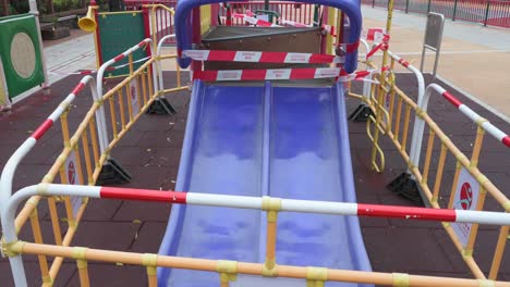 un juego de diapositivas cerrado con cintas y barreras visto en un parque público debido al brote de coronavirus covid-19 y restricciones en hong kon