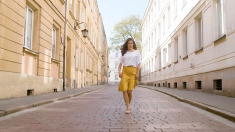 beautiful woman dancing latin dance alone in the old town street and looking at the camera