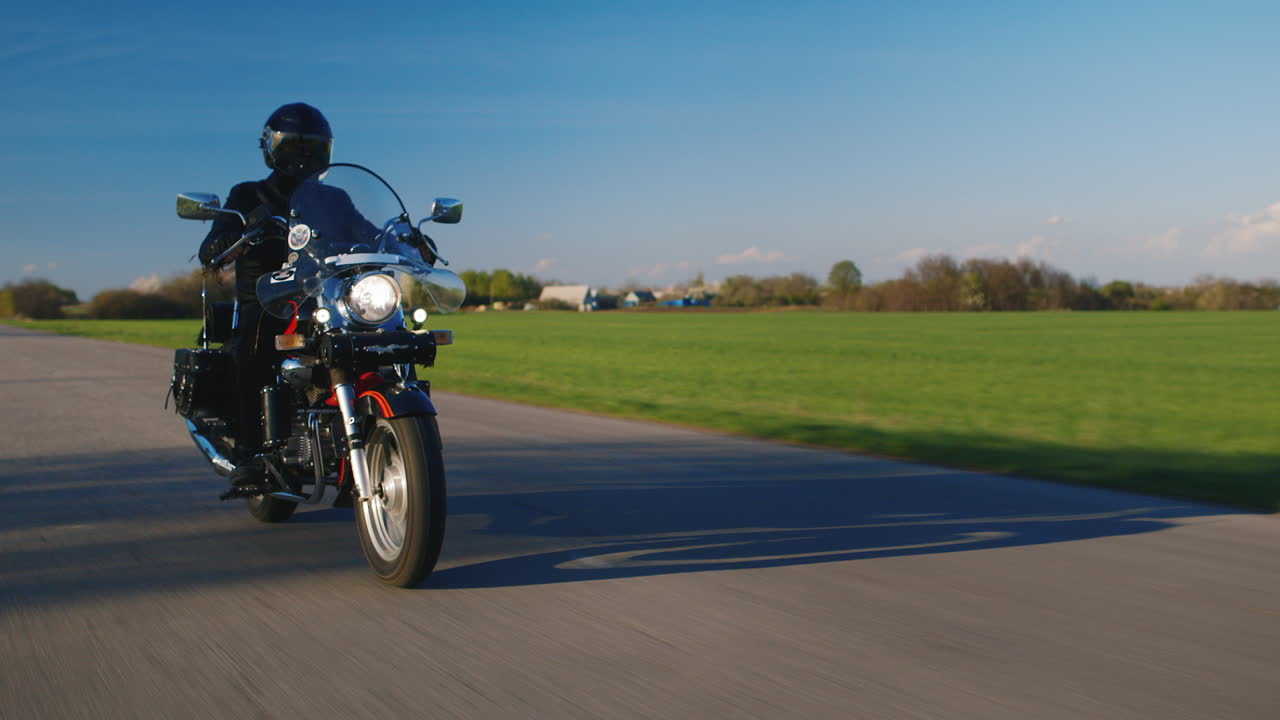motociclista en una motocicleta que viaja en un camino rural de fondo ligeramente borroso