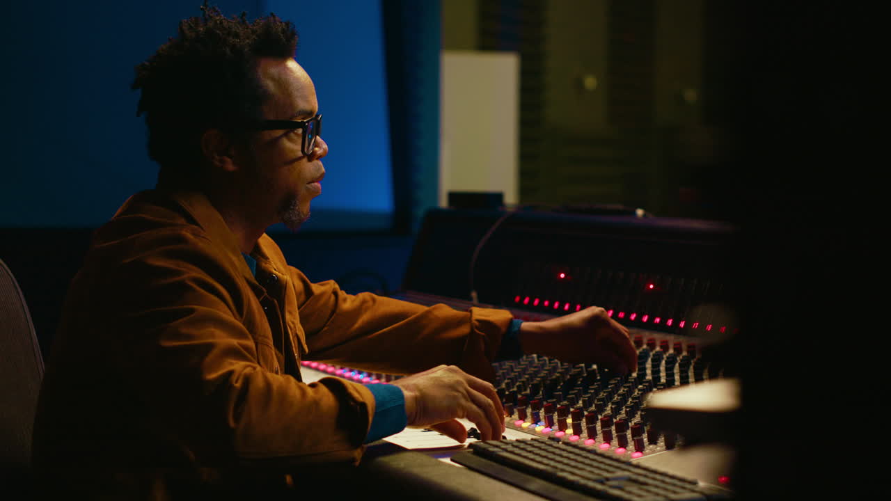 Portrait of professional sound engineer recording tracks and editing tunes