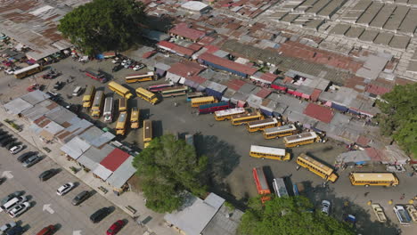 rotating aerial footage of a bus station in the market in antigua, guatemala