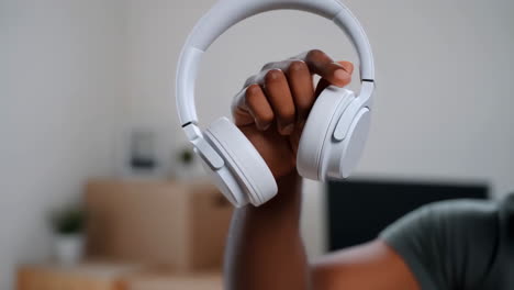 close-up of a person holding white wireless headphones
