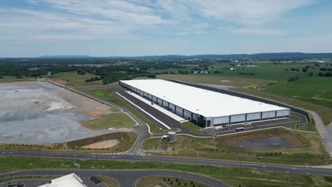 aerial drone view of business park that includes warehouses, factories, and gas station