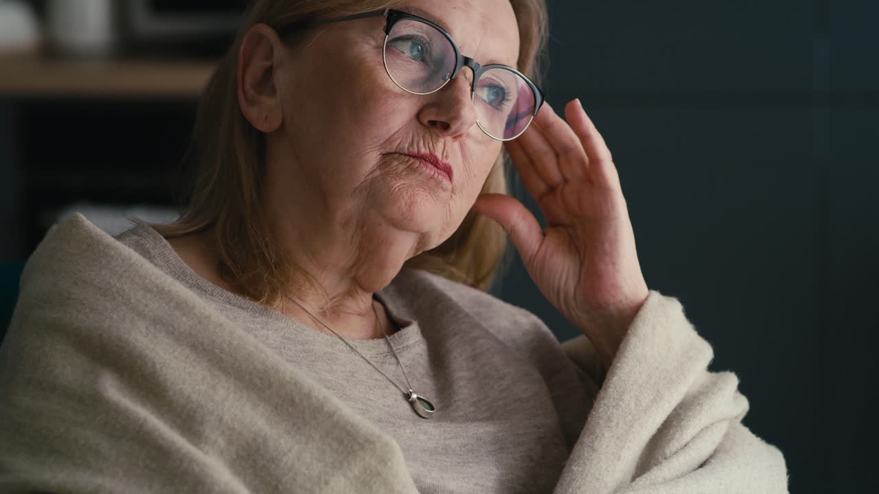 primer plano de una mujer mayor que tiene un fuerte dolor de cabeza y lo masajea