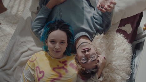 young romantic couple lying on bed with cigarette and looking at camera