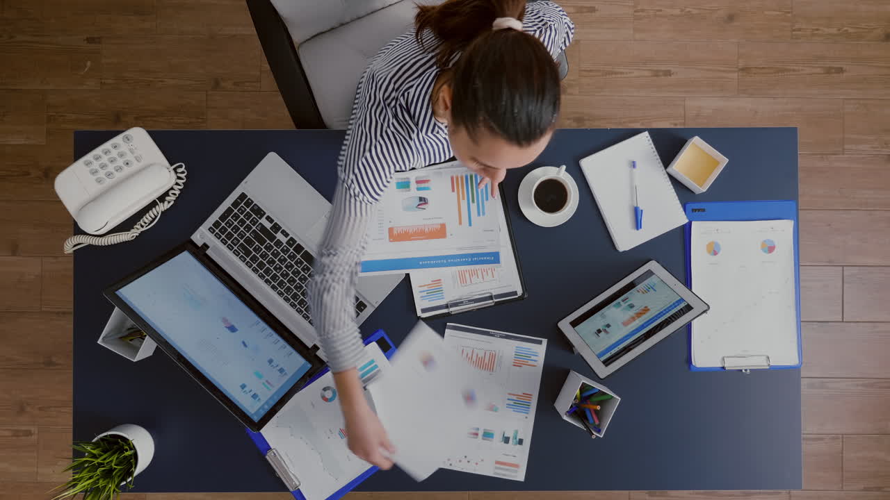 Top view of businesswoman sitting at desk table checking financial accounting documents