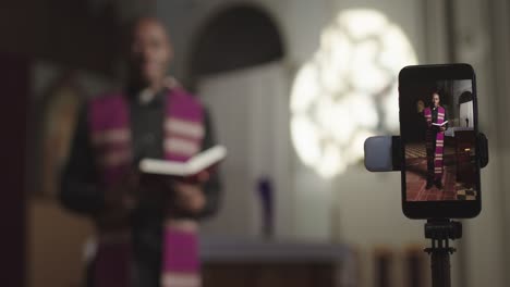 african-american priest recording sermon on smartphone camera