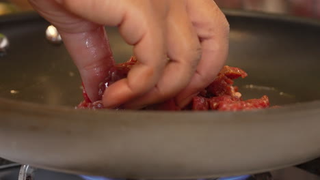 Stir-frying-slices-strips-of-skirt-or-flank-steak-in-a-pan-or-wok-with-oil-on-the-gas-stove---close-up-sizzling-in-slow-motion