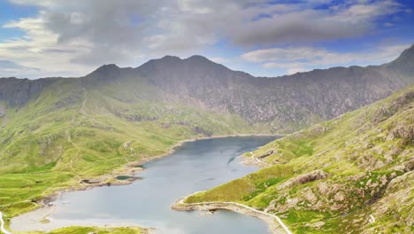 snowdonia national park wales, panoramic trucking aerial over llyn llydaw lake and the dramatic mountain landscape - cinematic drone footage of wild british landscapes