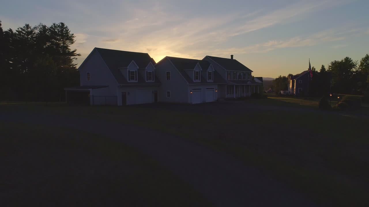A sunset hiding behind a big house- drone video