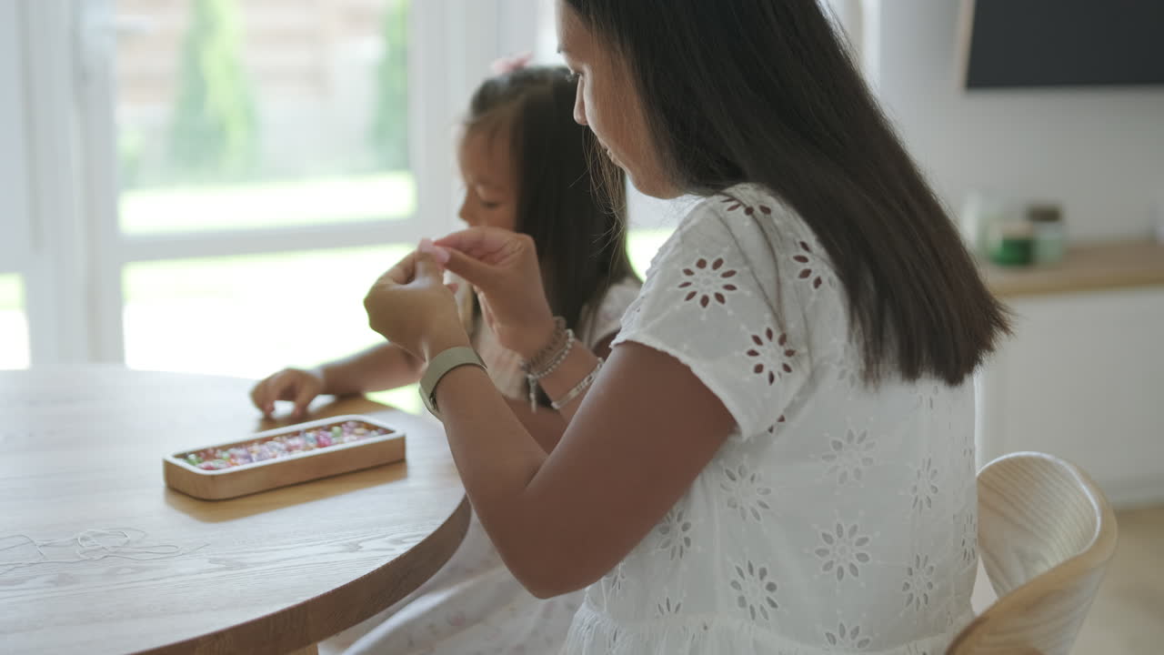 madre e hija haciendo joyas juntas