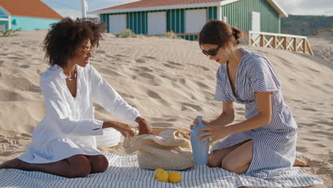 Pareja-Lgbt-Disfrutando-De-Un-Picnic-En-Casas-De-Playa-El-Soleado-Día-De-Verano.-Chicas-Felices-Descansan