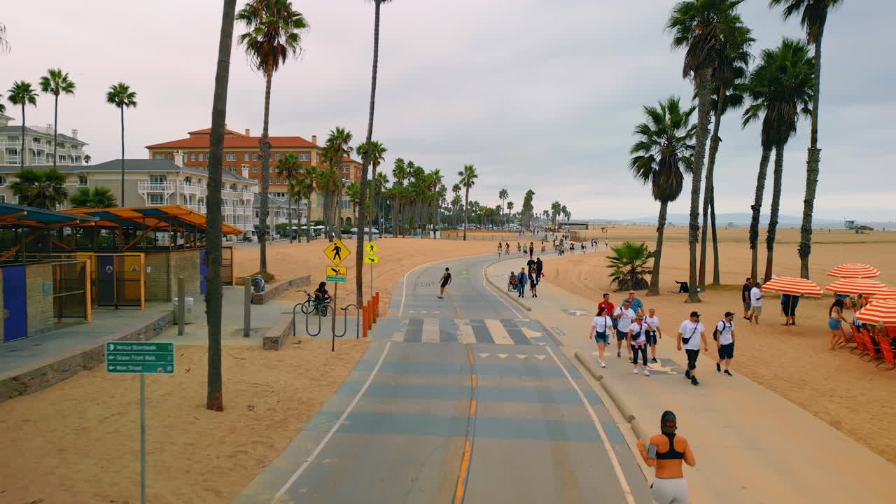Los Angeles, USA, 29 August 2025: People walk, run and skate along the beach in Santa-Monica. Gloomy day at the seaside of the Pacific Ocean